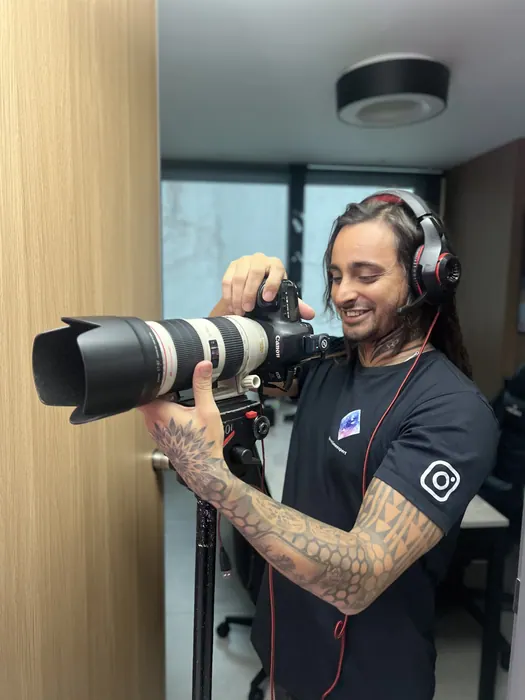 Operador com teleobjetiva e fone de comunicação